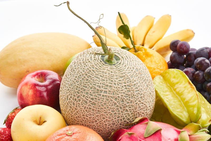 白色背景上摆放的生鲜混合水果图片