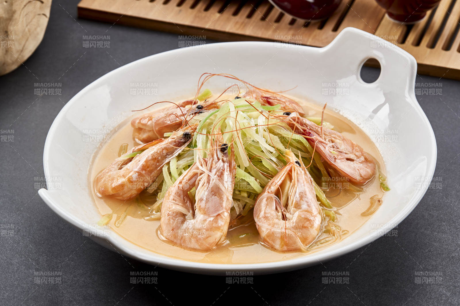 白色瓷耳盘装的西芹浓汤盐水大虾图片