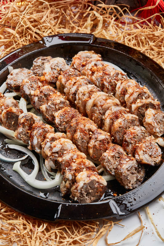 黑色铁盘装的香烤裹油羊肝图片