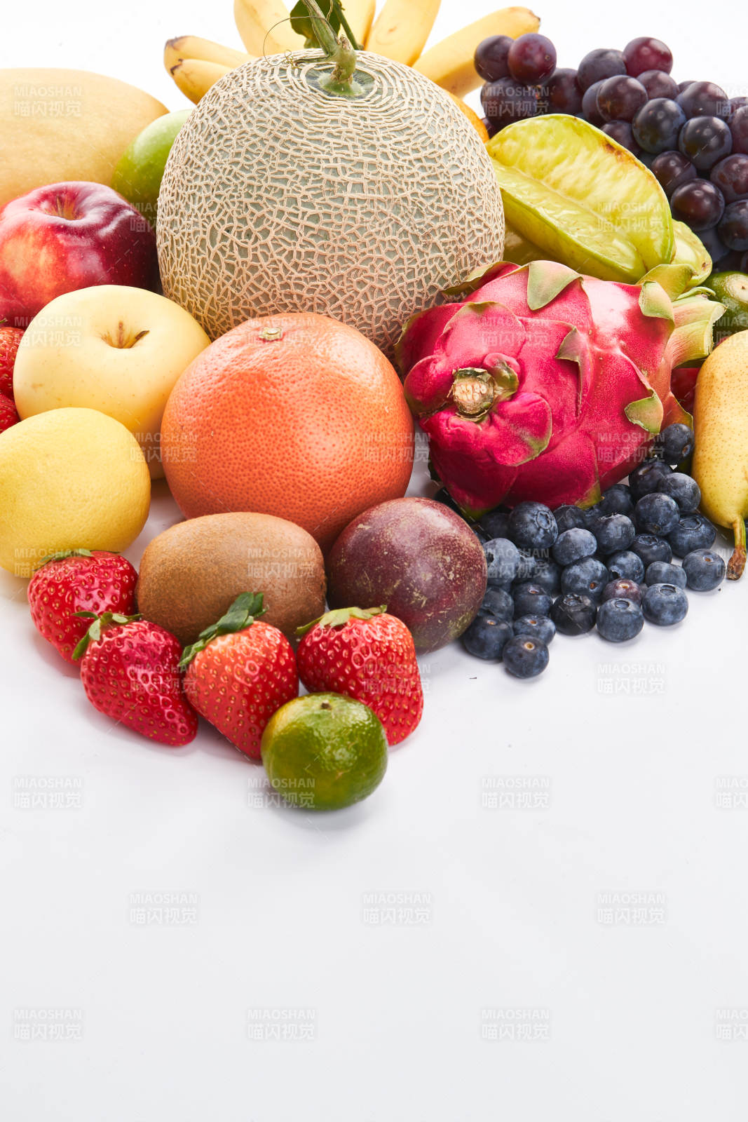 白色背景上摆放的生鲜混合水果图片