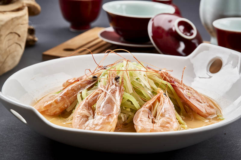 白色瓷耳盘装的西芹浓汤盐水大虾图片