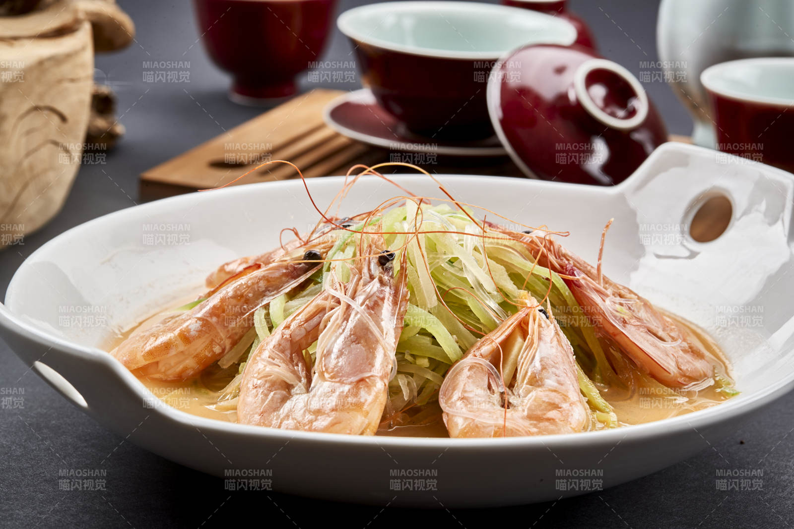 白色瓷耳盘装的西芹浓汤盐水大虾图片