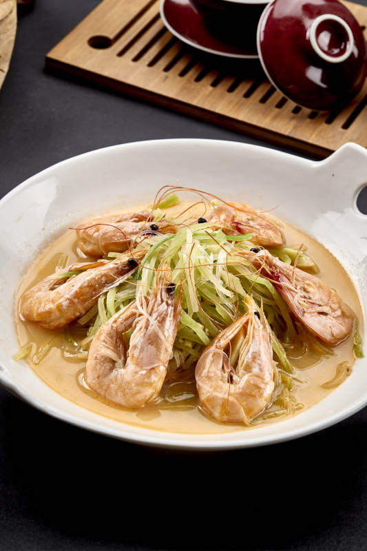 白色瓷耳盘装的西芹浓汤盐水大虾图片