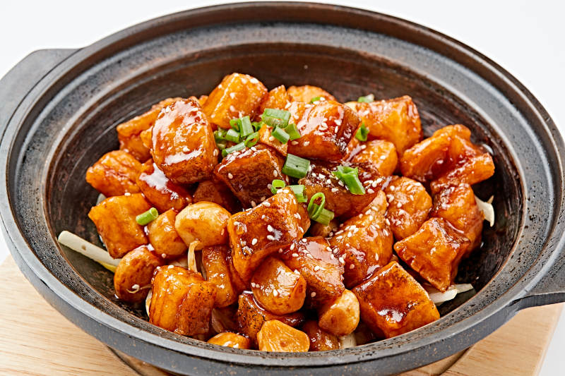 精美餐具装的砂锅煲仔蒜香鳕鱼粒图片