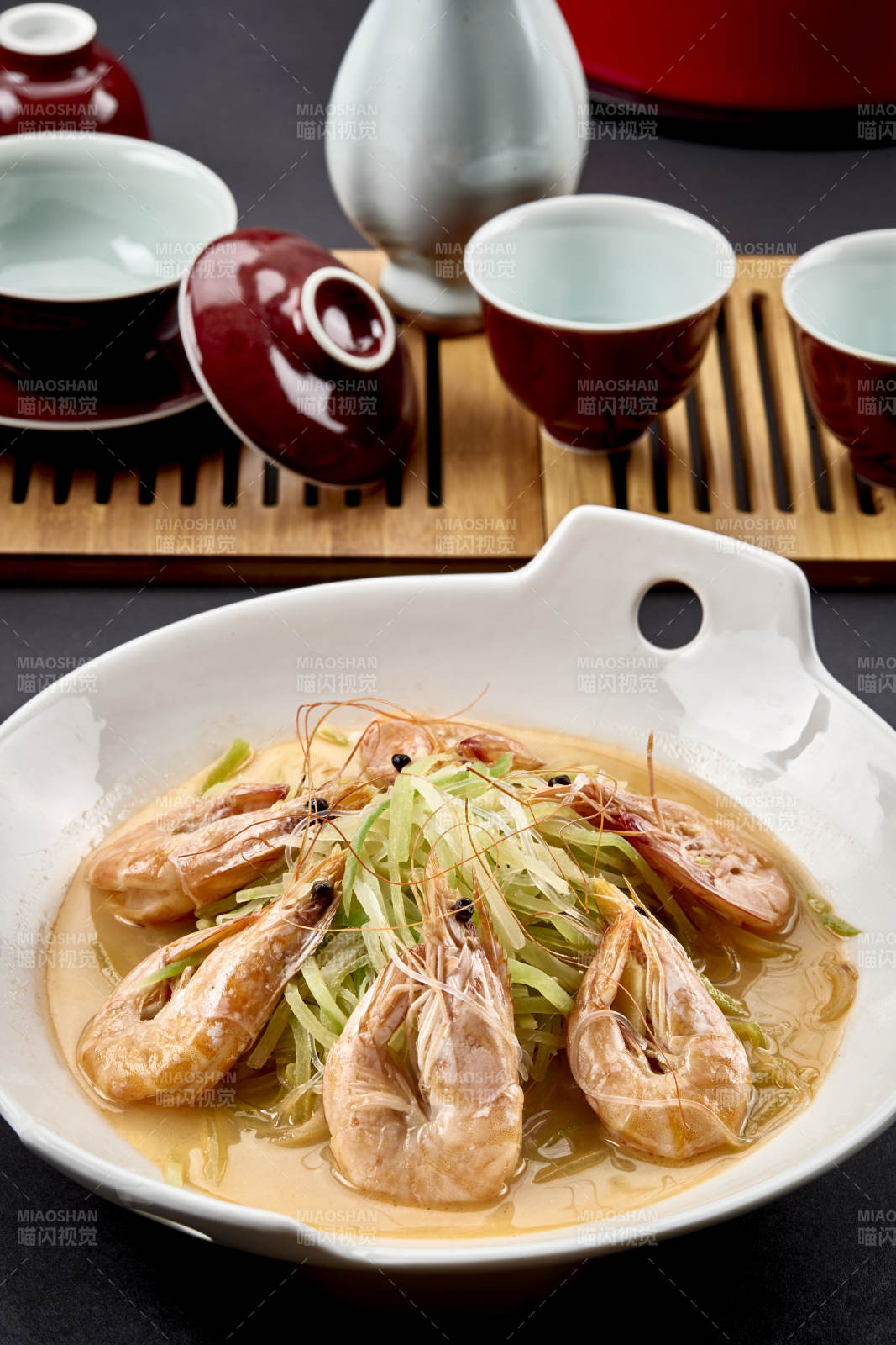 白色瓷耳盘装的西芹浓汤盐水大虾图片