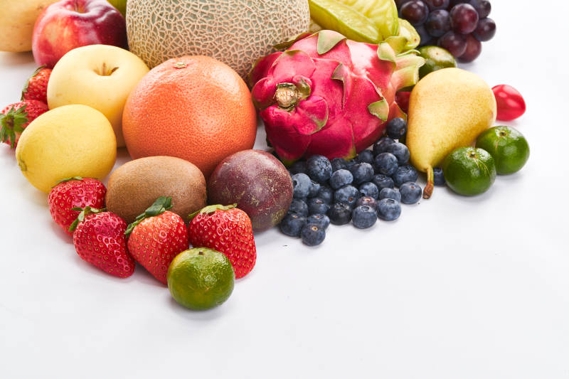 白色背景上摆放的生鲜混合水果图片