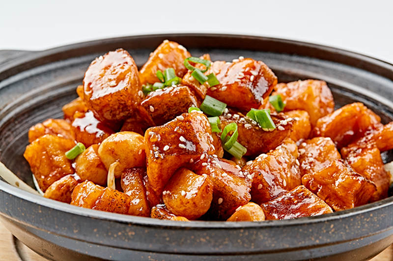 精美餐具装的砂锅煲仔蒜香鳕鱼粒图片