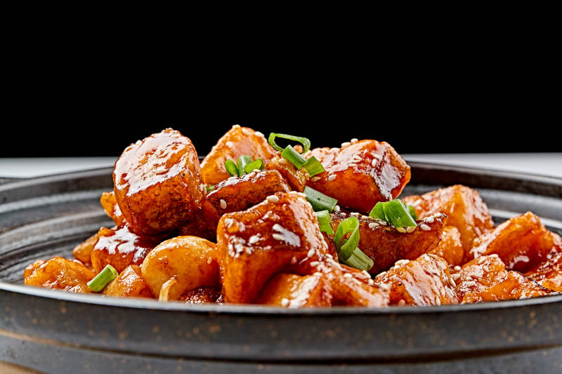 精美餐具装的砂锅煲仔蒜香鳕鱼粒图片