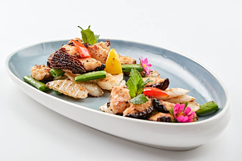 精美瓷盘装的黑胡椒彩椒蜜豆山药小炒羊肚菌图片