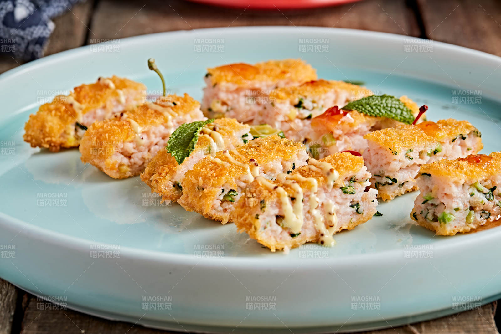 青色瓷盘装的油炸黄金虾饼图片