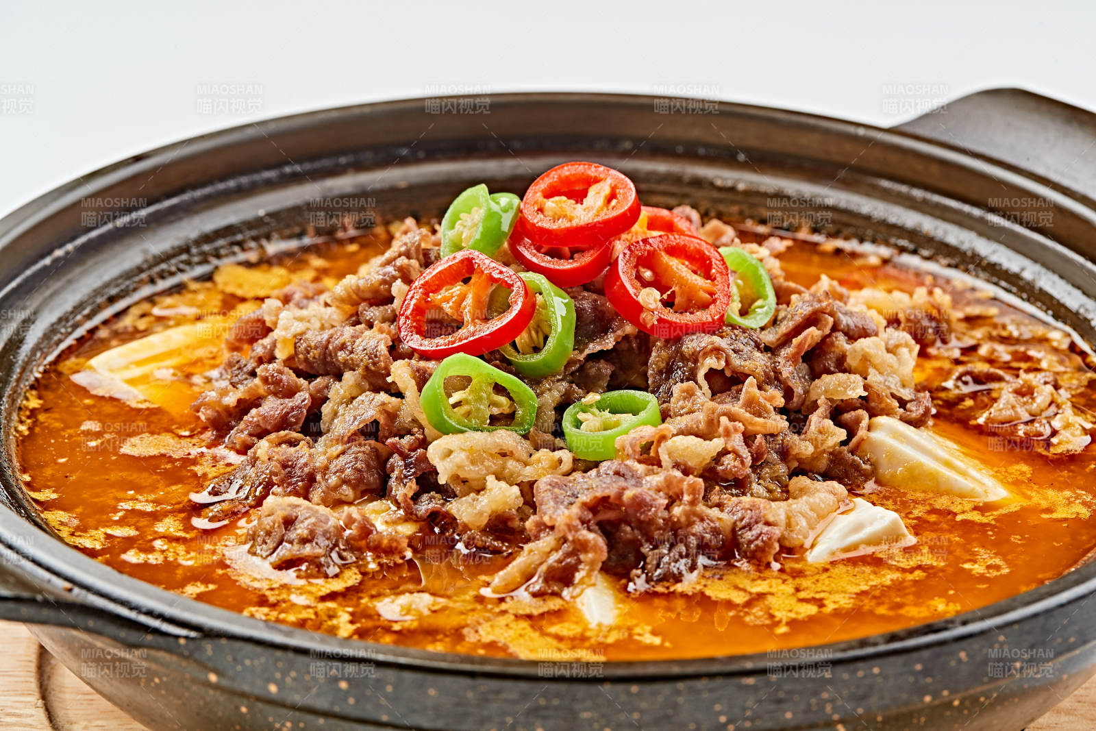 精美餐具装的砂锅香辣肥牛豆花图片