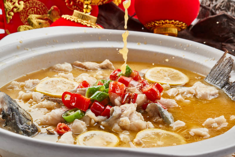 白色砂锅装的酸汤草鱼图片