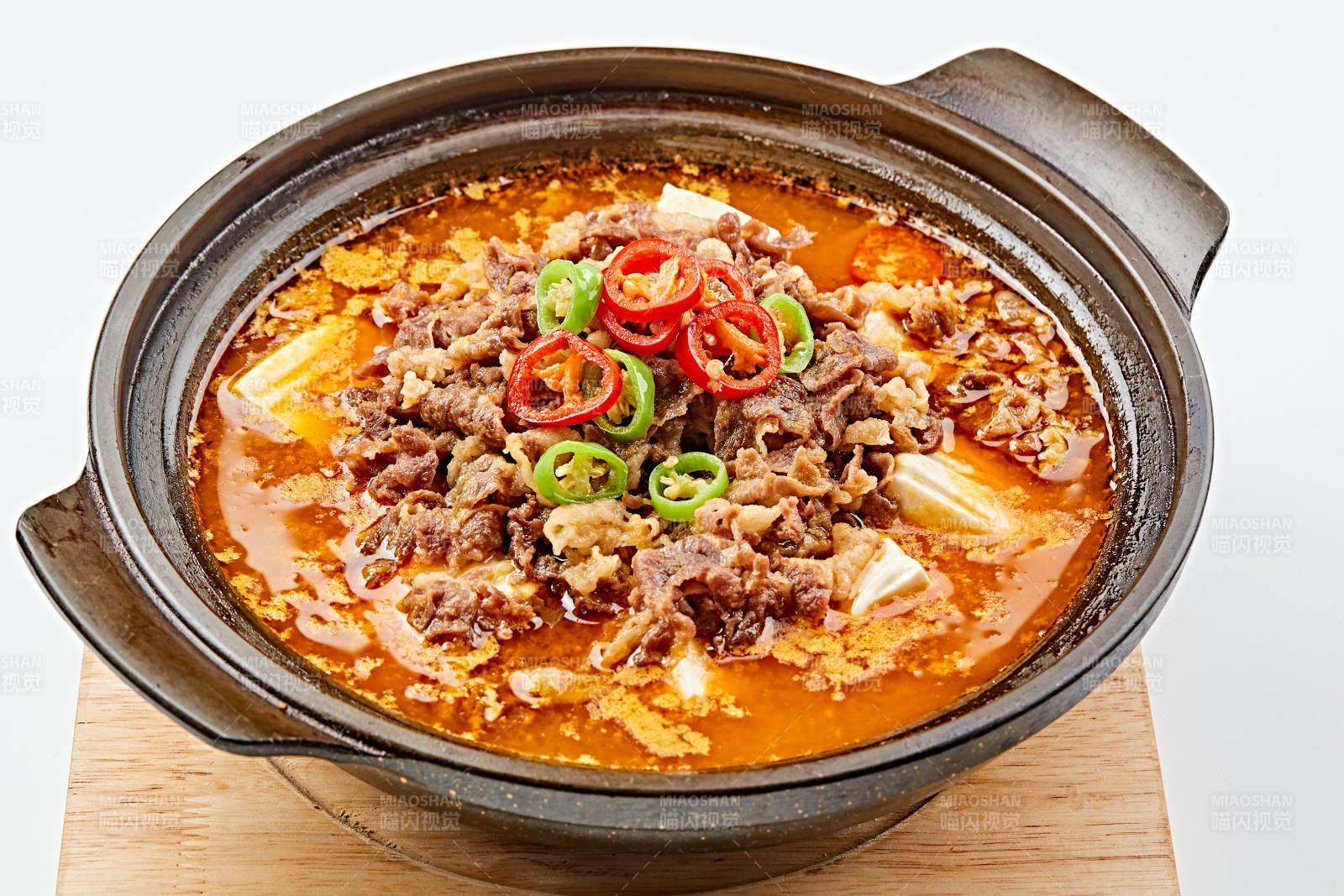 精美餐具装的砂锅香辣肥牛豆花图片