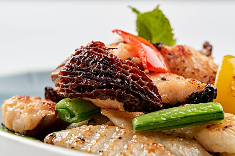 精美瓷盘装的黑胡椒彩椒蜜豆山药小炒羊肚菌图片