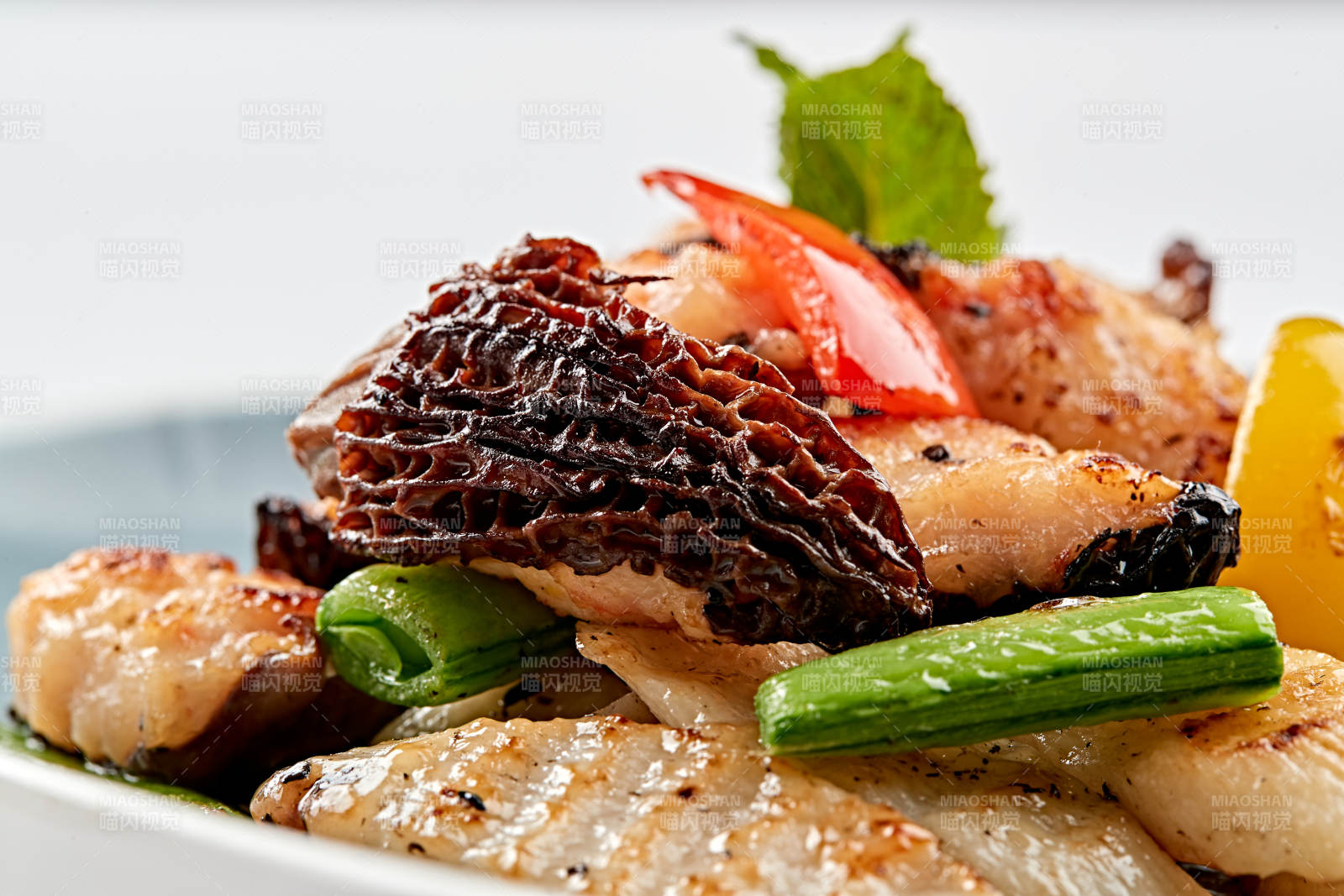 精美瓷盘装的黑胡椒彩椒蜜豆山药小炒羊肚菌图片