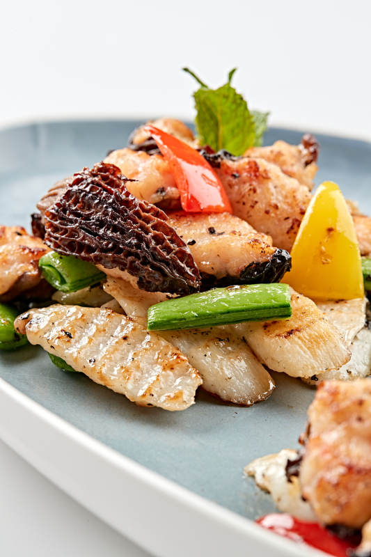 精美瓷盘装的黑胡椒彩椒蜜豆山药小炒羊肚菌图片