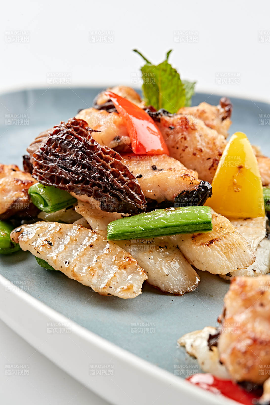 精美瓷盘装的黑胡椒彩椒蜜豆山药小炒羊肚菌图片