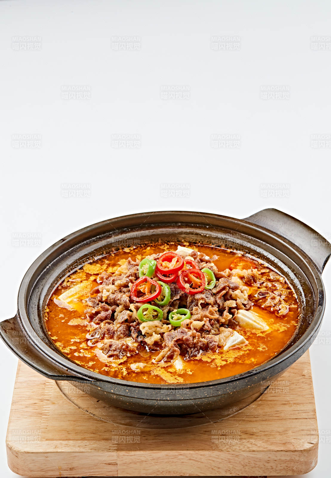 精美餐具装的砂锅香辣肥牛豆花图片