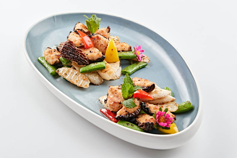 精美瓷盘装的黑胡椒彩椒蜜豆山药小炒羊肚菌图片