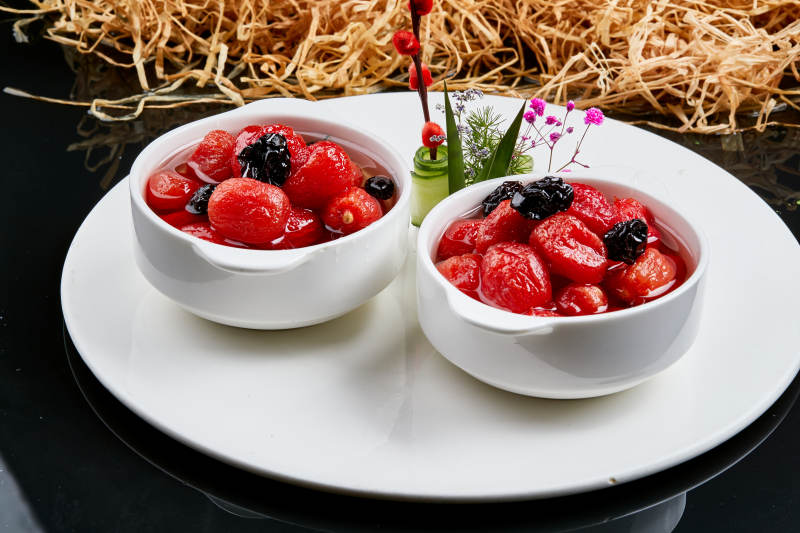 白色瓷碗装的腌渍糖水乌梅圣女果图片