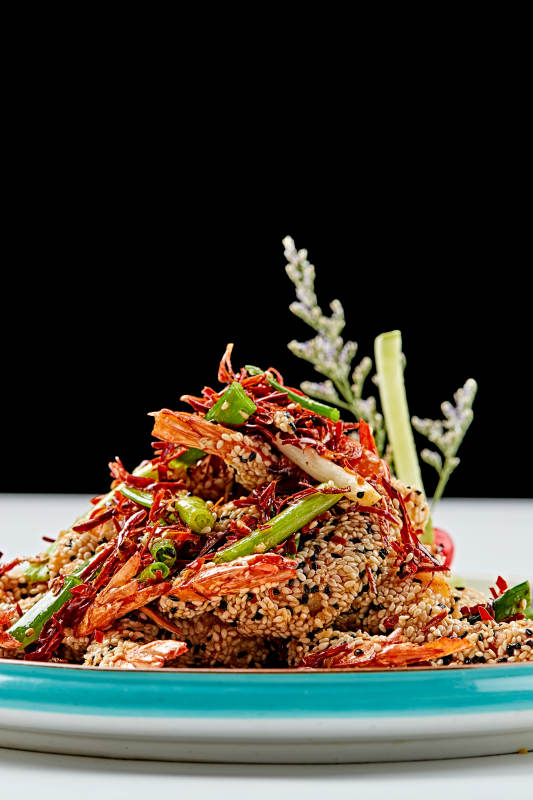 白色瓷盘装的油炸椒盐芝麻深海虾图片