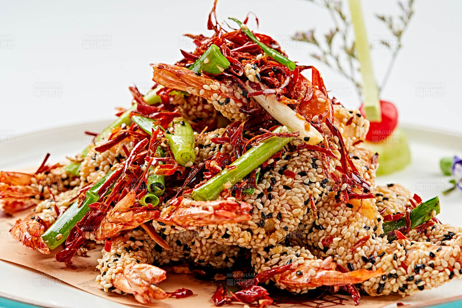 白色瓷盘装的油炸椒盐芝麻深海虾图片