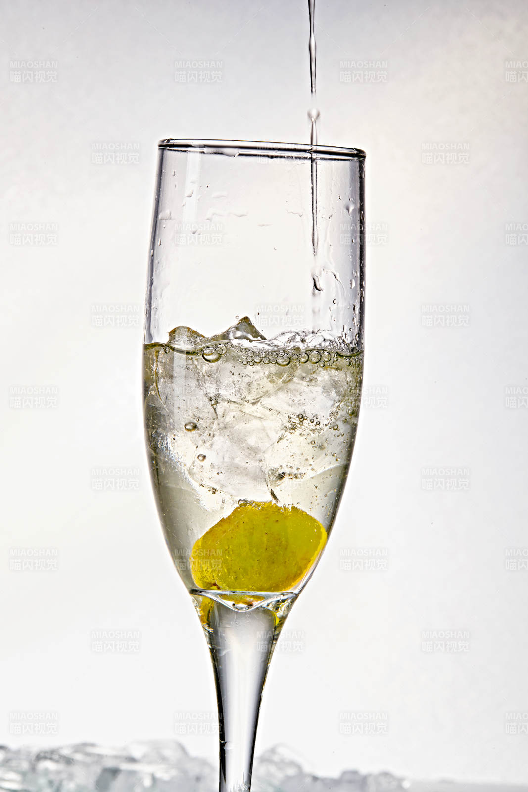 布满冰块的酒杯中的清凉白葡萄味预调酒图片