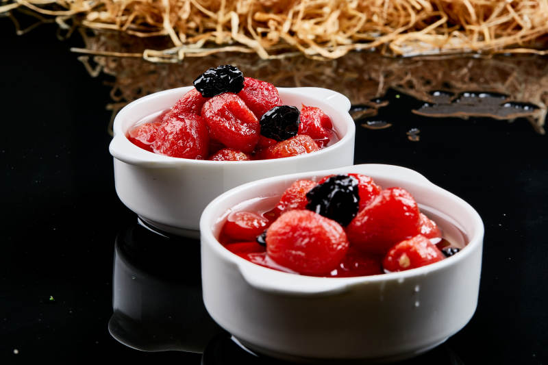 白色瓷碗装的腌渍糖水乌梅圣女果图片