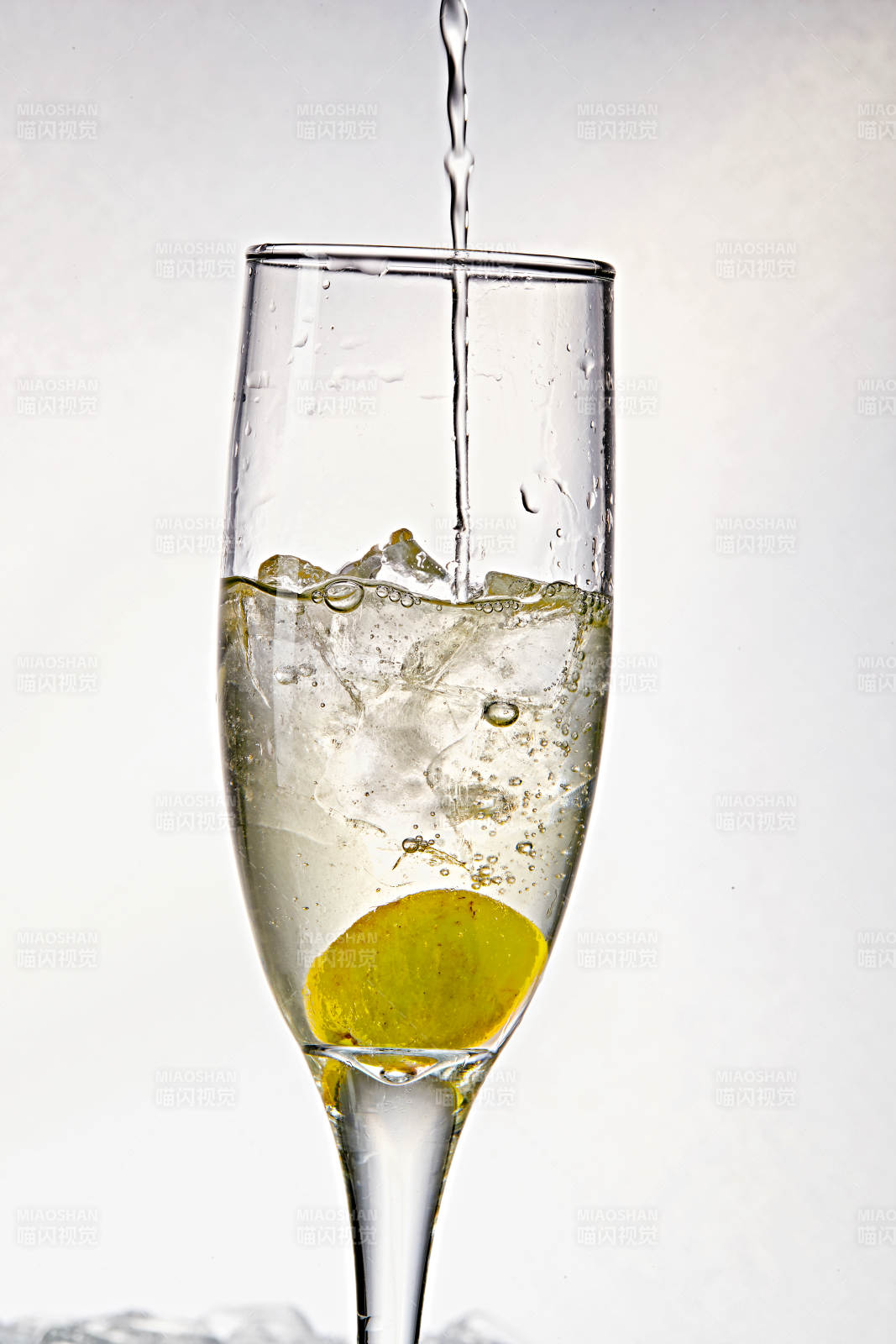 布满冰块的酒杯中的清凉白葡萄味预调酒图片