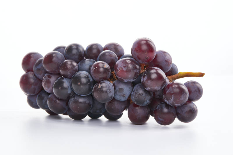 白色背景上摆放的水嫩新鲜紫葡萄图片