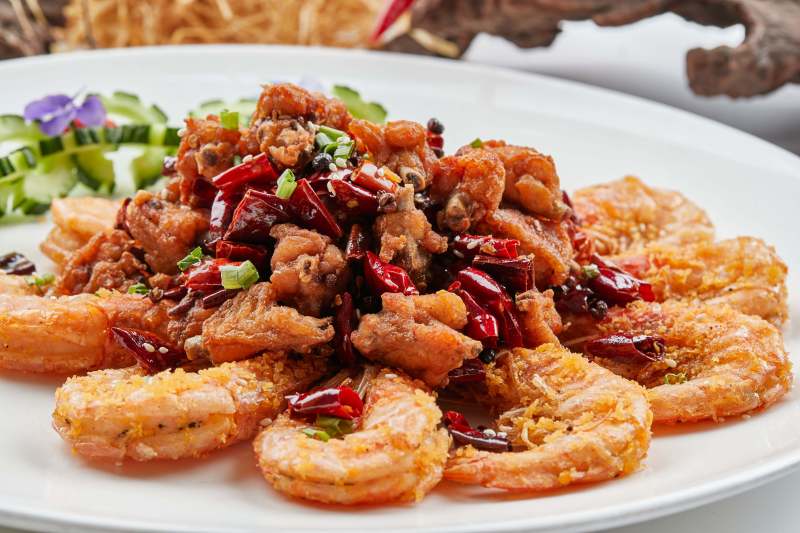 白色瓷盘装的香辣油炸鸡块开背虾图片