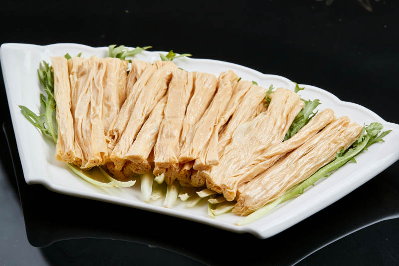 白色瓷盘装的火锅食材腐竹段图片