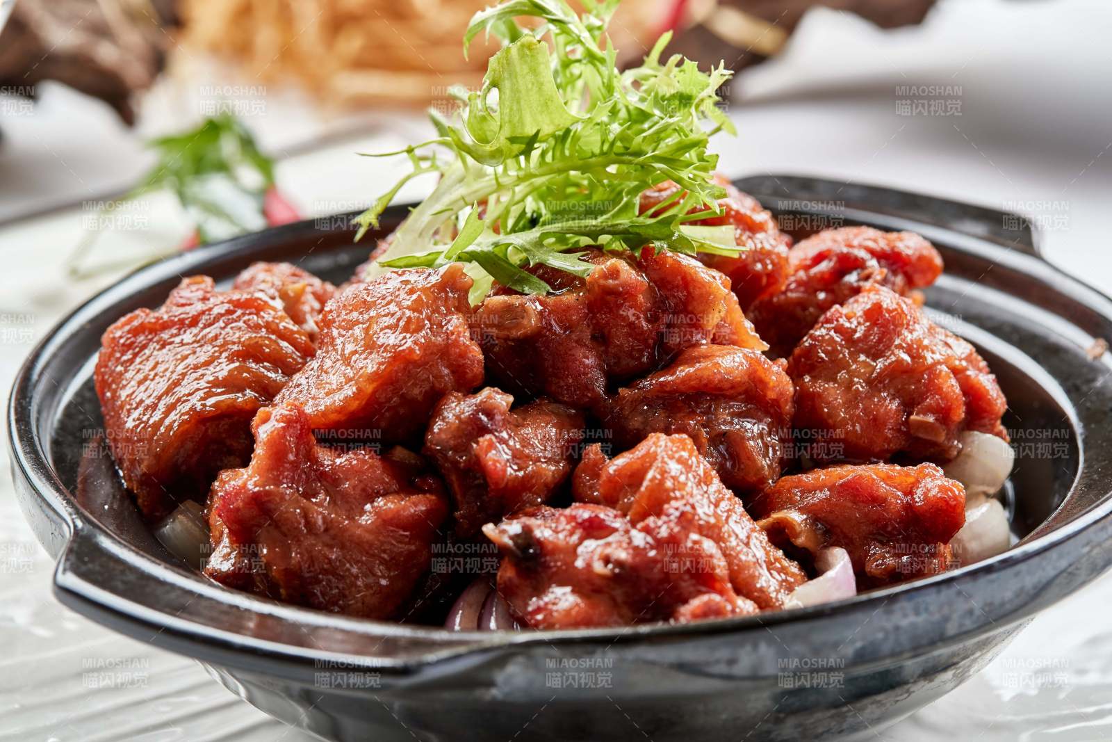 黑色砂锅装的葱香红烧鸡块图片