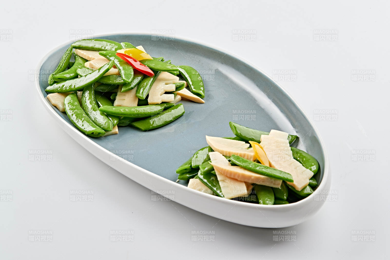 精美瓷盘装的冬笋彩椒炒蜜豆图片