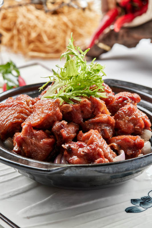 黑色砂锅装的葱香红烧鸡块图片