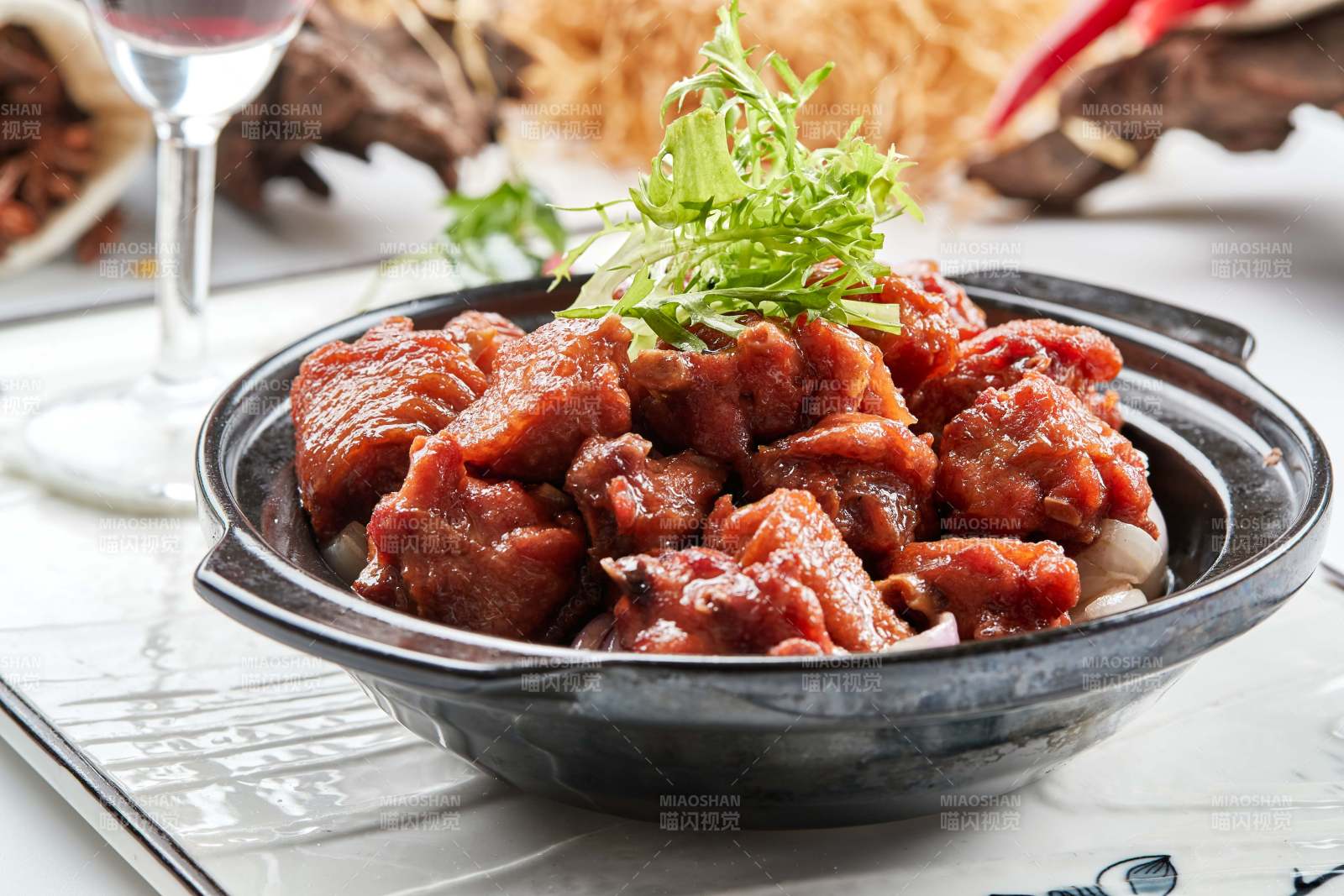 黑色砂锅装的葱香红烧鸡块图片