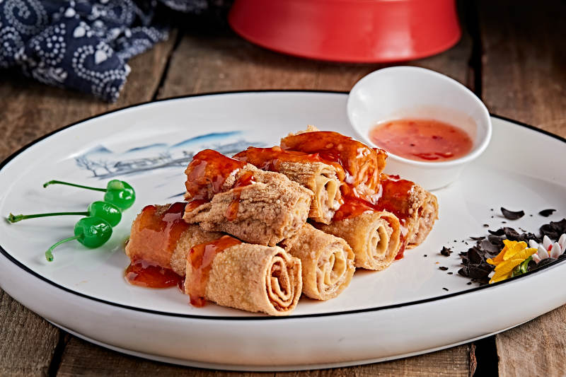 白色瓷盘装的浇汁油炸干豆腐卷图片