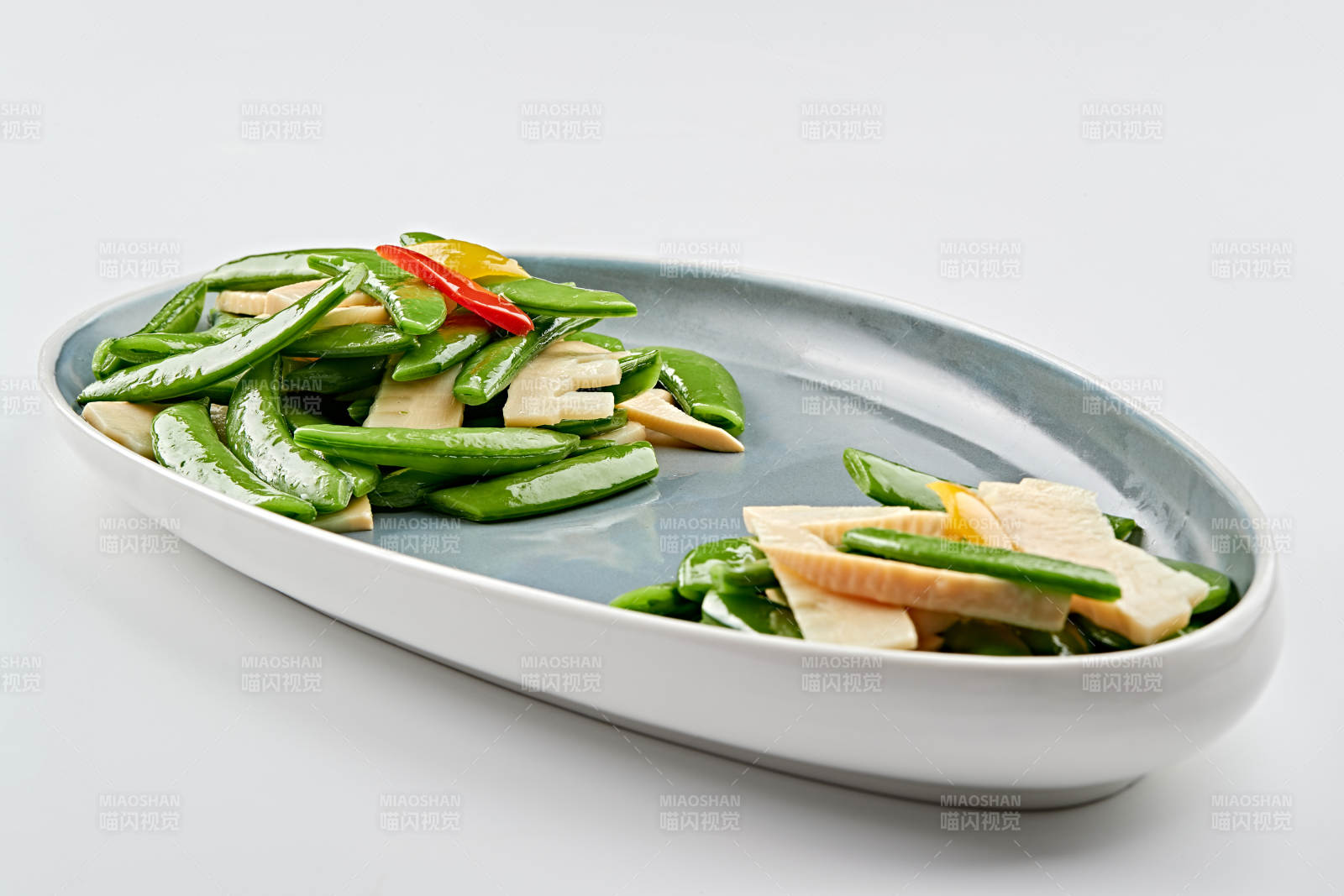 精美瓷盘装的冬笋彩椒炒蜜豆图片