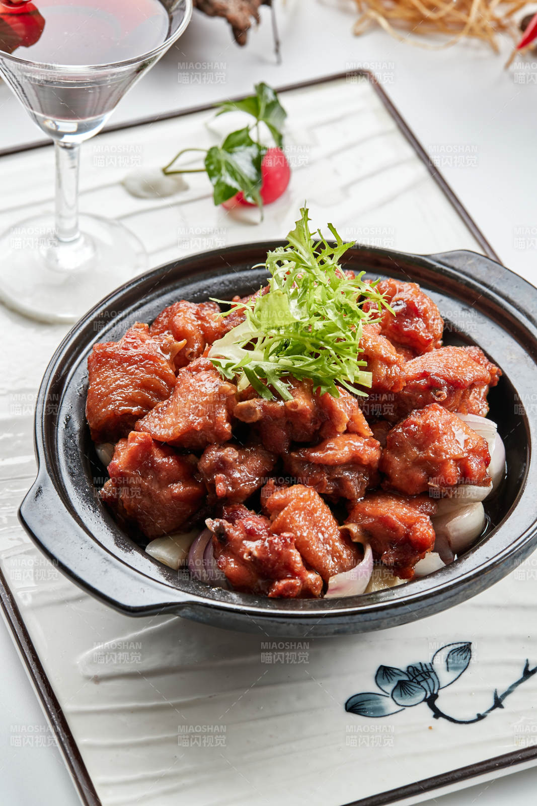 黑色砂锅装的葱香红烧鸡块图片