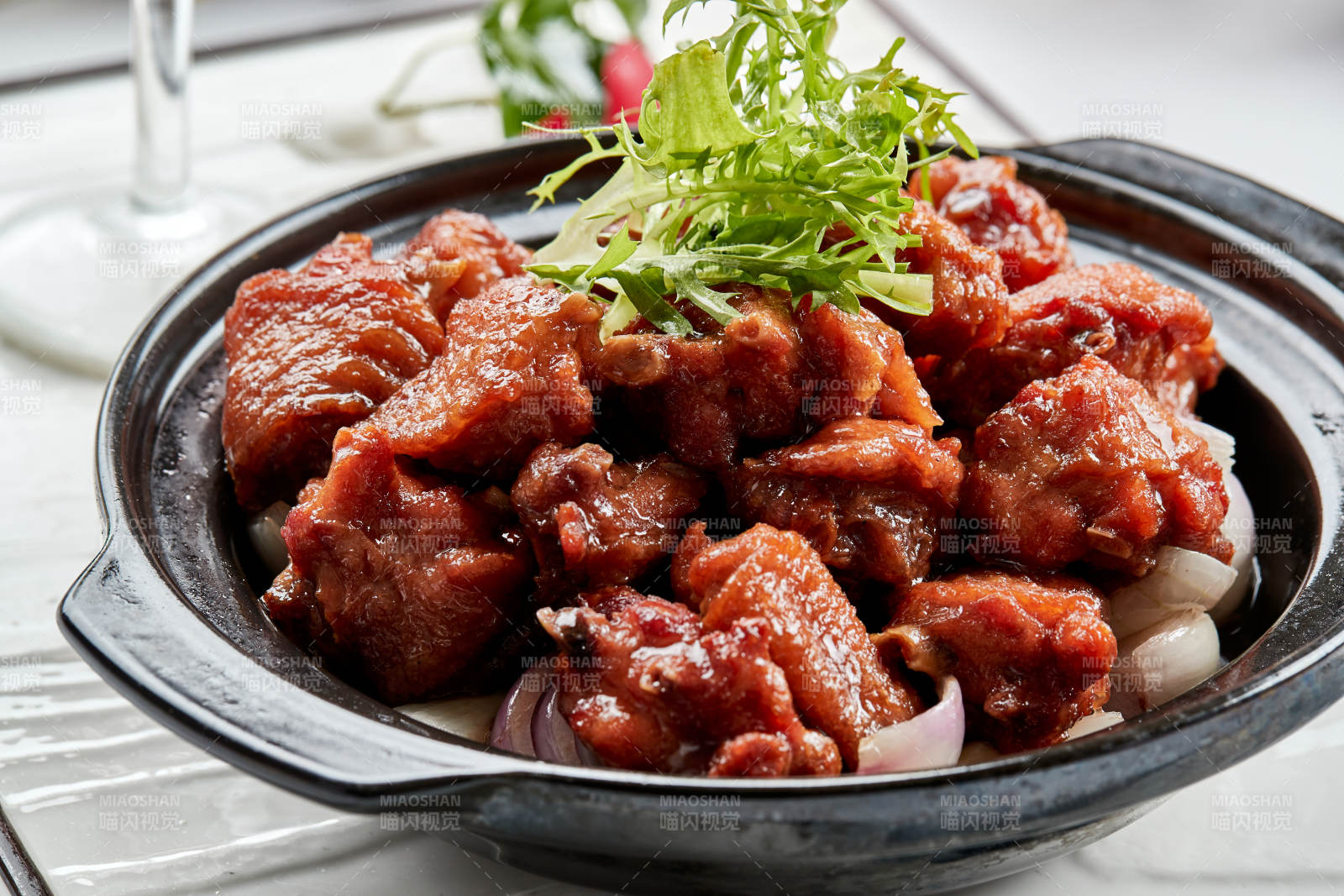 黑色砂锅装的葱香红烧鸡块图片