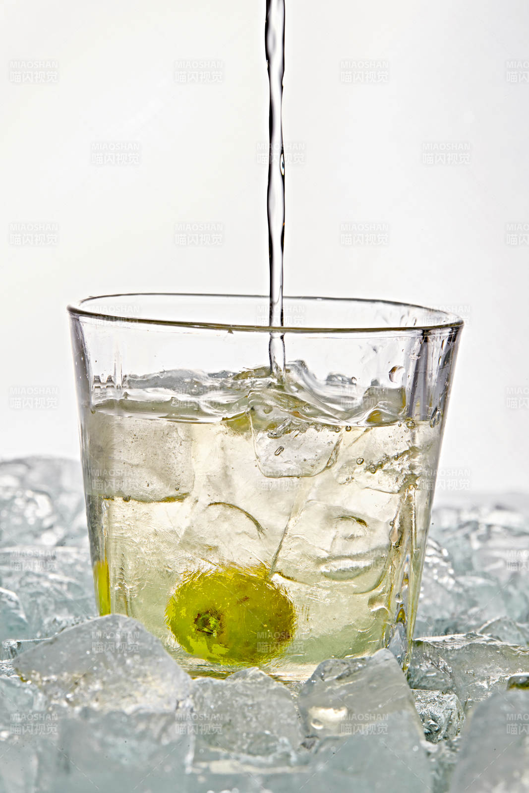 布满冰块的酒杯中的清凉白葡萄味预调酒图片
