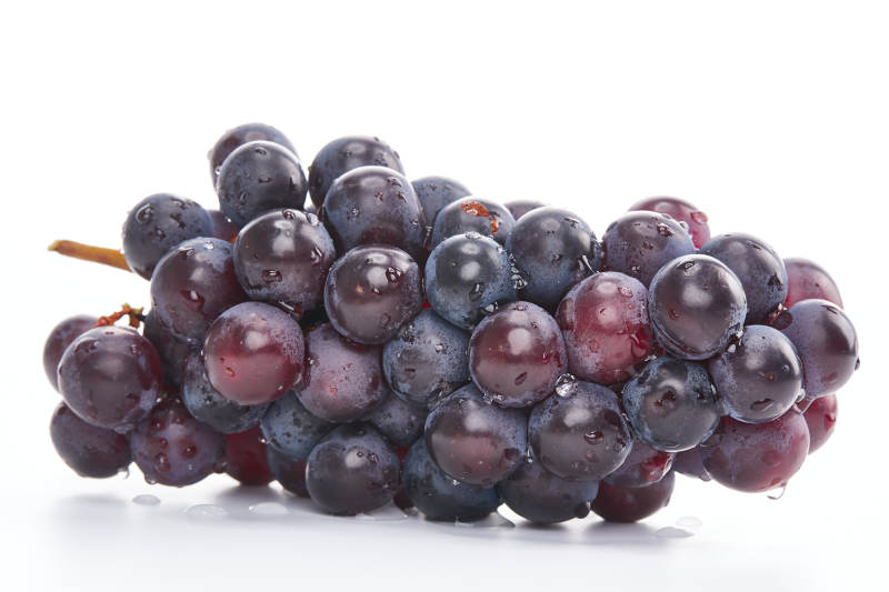 白色背景上摆放的水嫩新鲜紫葡萄图片