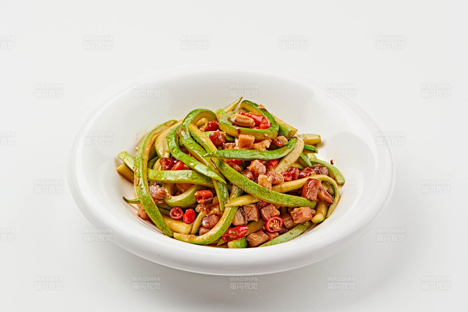 白色瓷盘装的葫芦条米椒炝炒腊肉丁图片