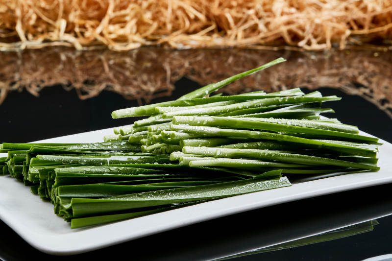 白色瓷盘装的火锅涮肉食材鲜韭菜图片