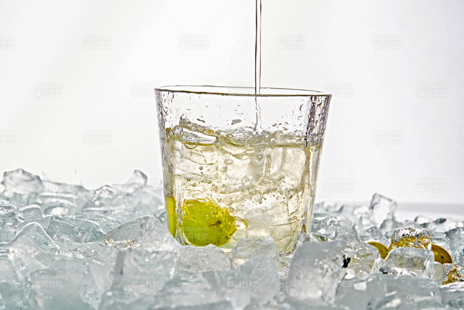 布满冰块的酒杯中的清凉白葡萄味预调酒图片
