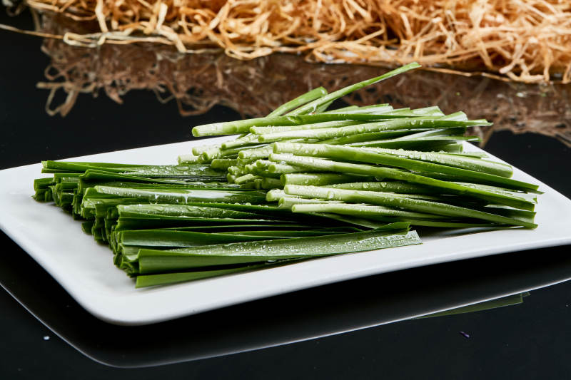 白色瓷盘装的火锅涮肉食材鲜韭菜图片