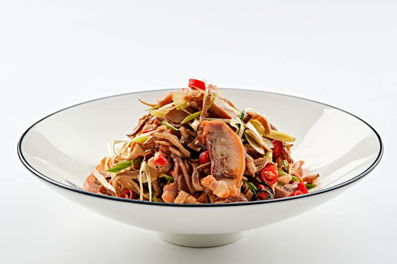 白色瓷盘装的香味小炒猪头肉图片