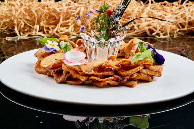 白色瓷盘装的糖腌杏鲍菇片图片