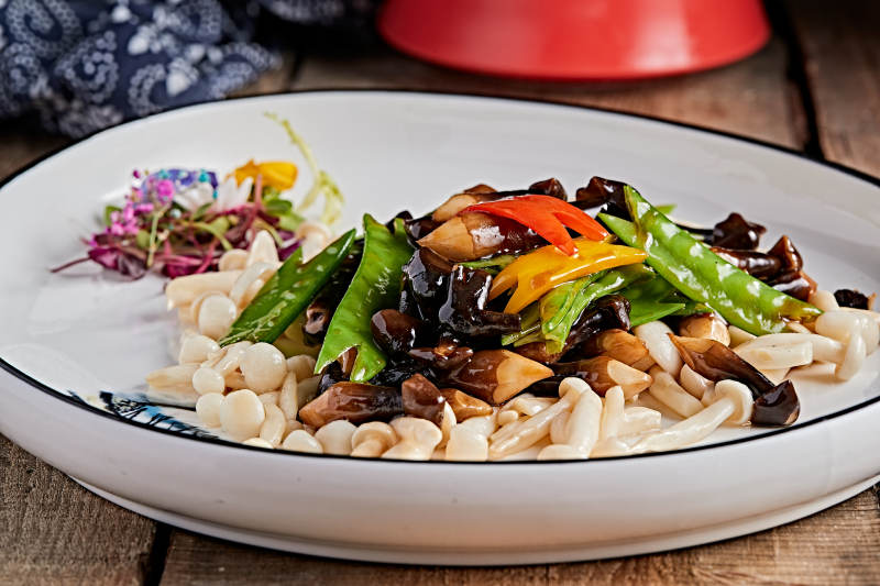 精美瓷餐具装的荷兰豆小炒杂菌图片