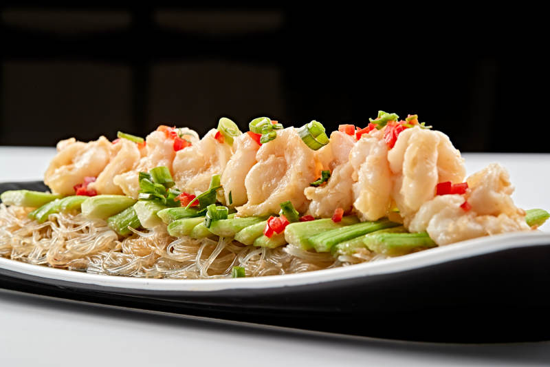 黑色磁盘装的浇汁粉丝蒸虾仁图片